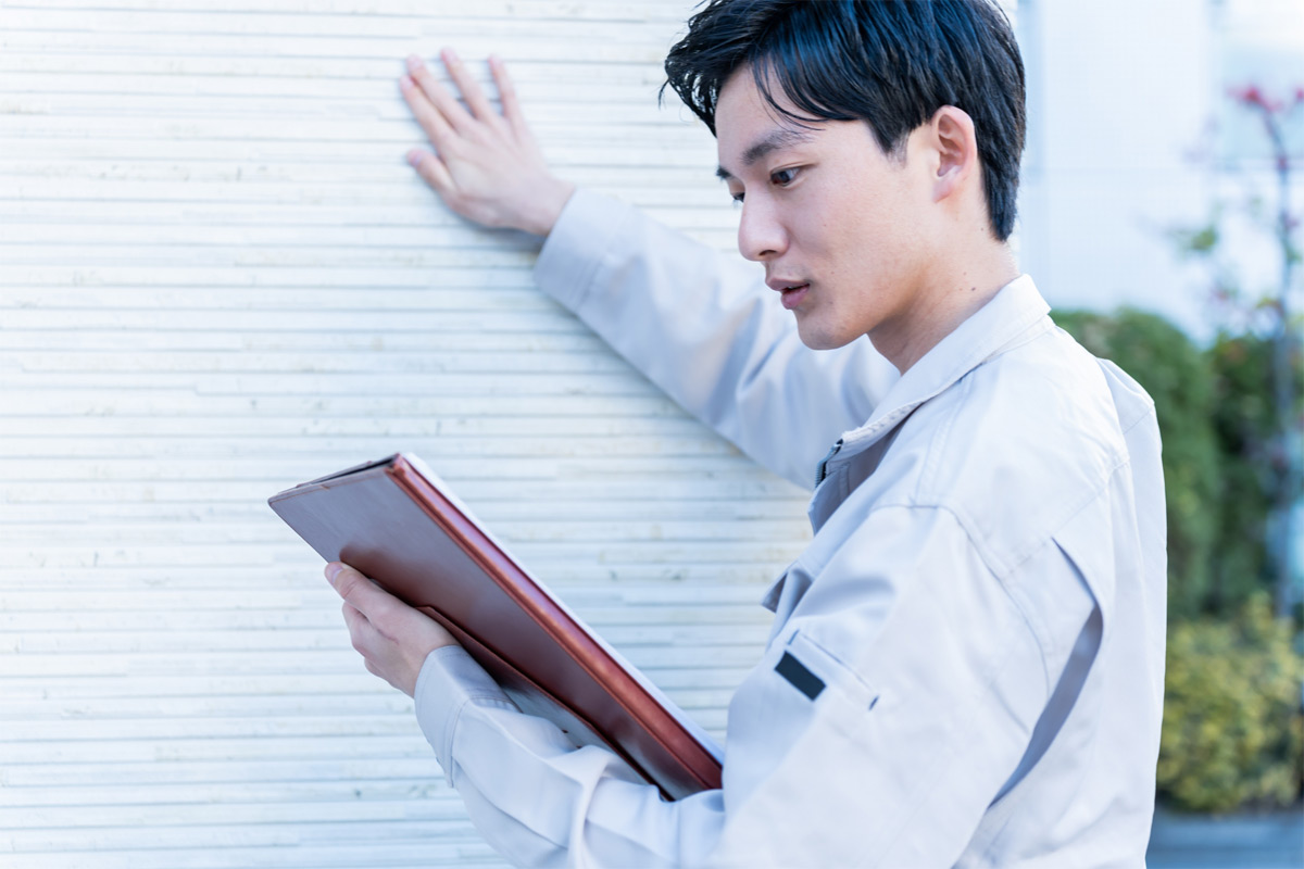 工事後の壁を点検する業者 